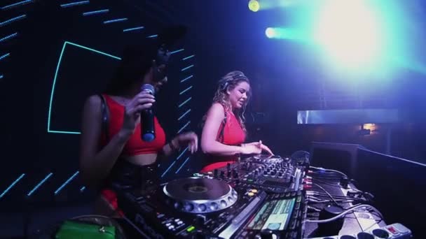 Petrohrad, Rusko - 30. června 2016: Mc dívka v Zaječí masku a dj dívka v červených šatech provést na točnu v nočním klubu. — Stock video