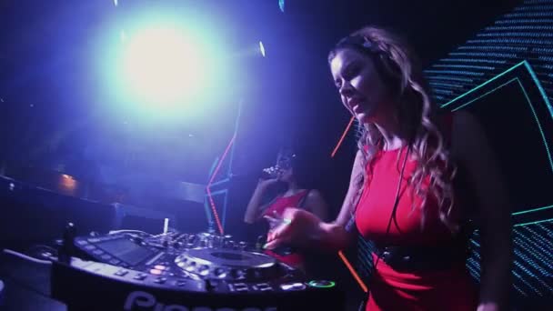 Sankt Petersburg, Ryssland - 30 juni 2016: Mc flicka i hare mask och dj flicka i röd klänning på skivspelare i nattklubb. Mix — Stockvideo
