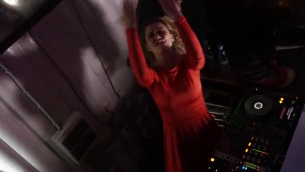 Petrohrad, Rusko - 17. června 2016: Dj dívka v červených šatech dance na gramofonu na párty v nočním klubu. Skok. Protřepejte vlasy. — Stock video