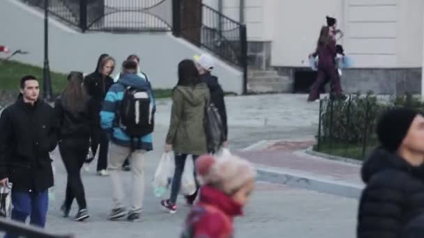 SOCHI, RUSIA - 27 de marzo de 2016: Vista de muchas personas caminando por la calle. Amigos, snowboarders en uniforme. Edificios. Noche en la ciudad . — Vídeos de Stock