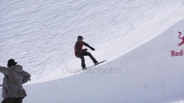 Sochi, Rusya Federasyonu - 1 Nisan 2016: Snowboarder sıçrama tahtası atlamak, aşırı flips olun. Peyzaj dağlar.