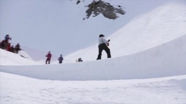 Soçi, Rusya - 1 Nisan 2016: Snowboarder sıçrama sıçrama tahtası üzerinden yapmak tehlikeli çevirir. Manzara. Güneşli gün