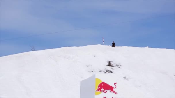 Sochi, Rusko - 1. dubna 2016: Snowboardista skok od fly odrazový můstek nad modré kostky. Krajina hor. — Stock video