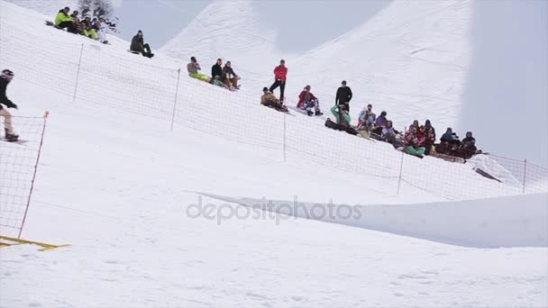 СОЧИ, РОССИЯ - 1 апреля 2016 года: Сноубордист прыгает с трамплина, делает сальто. Горы. Крайне. Люди — стоковое видео