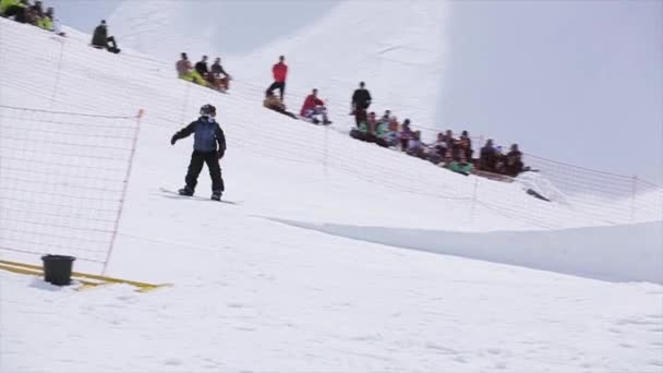 Sochi, Rusko - 1. dubna 2016: Snowboardista skok podobě odrazový můstek, aby překlopit ve vzduchu. Lyžařské středisko. Extrémní. Lidé — Stock video