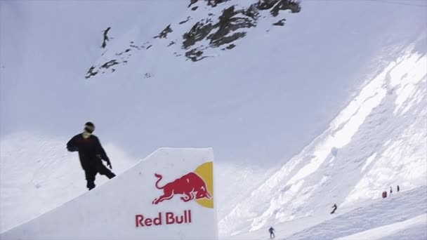 Sochi, Rusko - 1. dubna 2016: Snowboardista skok z odrazový můstek udělat kotrmelec. Hory. Adrenalinu. Lidé — Stock video