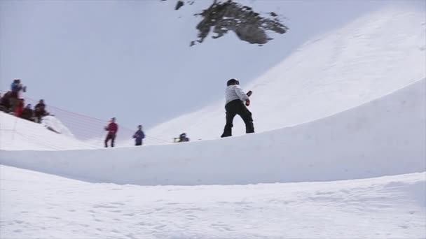 SOCHI, RÚSSIA - 1 de abril de 2016: Snowboarder jump from springboard, make dangerous flips. Paisagem. Dia ensolarado — Vídeo de Stock