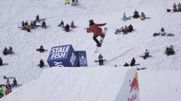 SOCHI, RUSIA - 1 DE ABRIL DE 2016: Los snowboarders saltan desde el trampolín, hacen acrobacias extremas. La gente se relaja en la pendiente . — Vídeo de stock