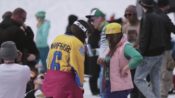 SOCHI, RUSIA - 1 DE ABRIL DE 2016: Personas en el campamento en la estación de esquí. Chica con camisa amarilla. Snowboarders, esquiadores . — Vídeos de Stock
