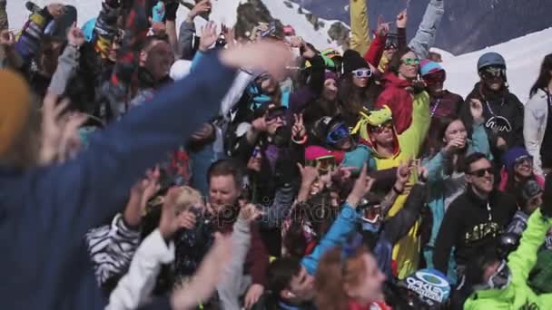 SOCHI, RUSIA - 1 DE ABRIL DE 2016: Multitud de personas levantan las manos en el campamento en la estación de esquí. Día soleado. Evento. Traje — Vídeo de stock