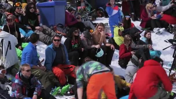 SOCHI, RUSSIA - APRIL 1, 2016: Crowd of people relax in encamp. Ski resort. Snowboarders and skiers. Sunny day. — Stock Video