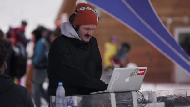 Sochi, Rusland - 1 April 2016: Skiresort. In de rode hoed, koptelefoon spinnen bij draaitafel, DJ laptop. Encamp. — Stockvideo