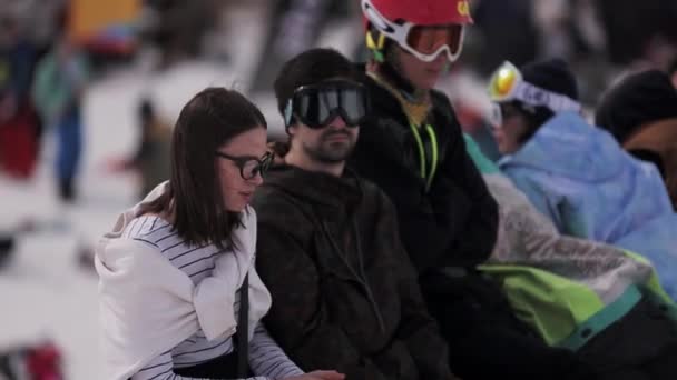 SOCHI, RÚSSIA - 1 de abril de 2016: As pessoas relaxam no acampamento. Estância de esqui. Snowboarder. Dia ensolarado. Menina de óculos. Sol — Vídeo de Stock