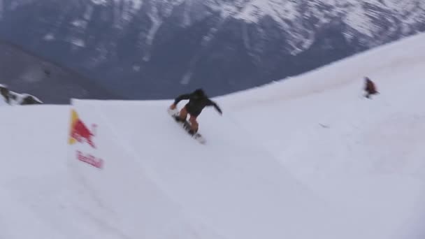 СОЧИ, РОССИЯ - 1 апреля 2016 года: Сноубордист совершает экстремальные прыжки с трамплина. Горы. Лыжный курорт. Скорость — стоковое видео