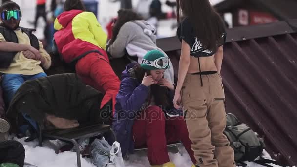 SOCHI, RUSIA - 1 DE ABRIL DE 2016: La gente se relaja en el campamento. Estación de esquí. Snowboarder. Soleado. Cuatro chicas en gafas de sol — Vídeos de Stock