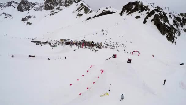 Сочі, Росія - 4 квітня 2016: Стріляти сноубордистів Quadrocopter та лижників їздити на гірськолижному курорті. Снігові гори — стокове відео