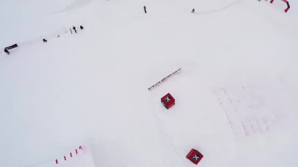 SOCHI, RUSIA - 4 DE ABRIL DE 2016: Quadrocopter disparar trampolines en la estación de esquí. Montañas nevadas. Jinetes. Antena — Vídeos de Stock