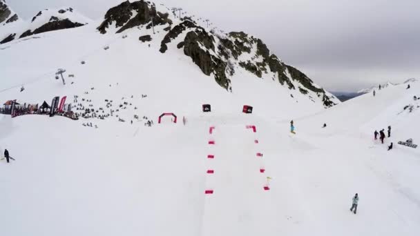 Sochi, Rusko - duben 4, 2016: Quadrocopter natáčení snowboardista se převrátit ve vzduchu. Lyžařské středisko. Klesá. Lidé — Stock video