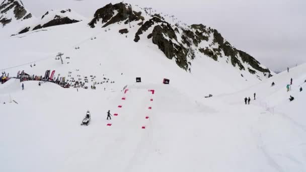 SOCHI, RUSSIA - APRIL 4, 2016: Quadrocopter shoot ski resort. Snowy mountains. Skier jump from springboard — Stock Video