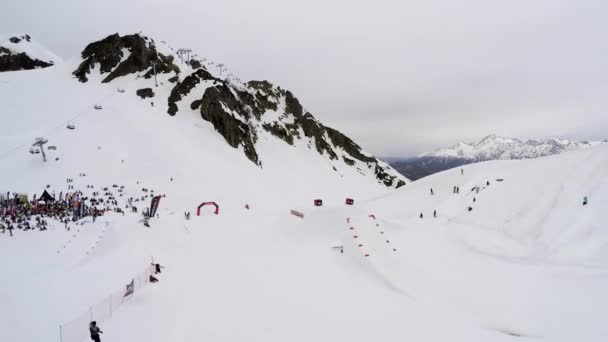 Sochi, Rusland - 4 April 2016: Quadrocopter schieten skiresort. Bergen. Snowboarder sprong van springboad — Stockvideo