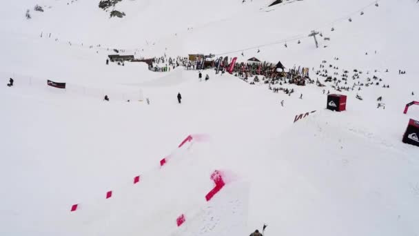 Sochi, Rusko - duben 4, 2016: Quadrocopter natáčení snowboardista, aby skočit z můstku, chytit ve vzduchu. — Stock video