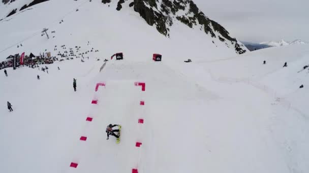 SOCHI, RUSIA - 4 DE ABRIL DE 2016: Quadrocopter disparar snowboarder salto desde el trampolín, hacer volteretas en el aire. Extremo. — Vídeos de Stock