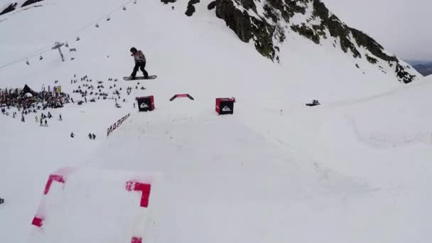 Sochi, Rusko - duben 4, 2016: Quadrocopter natáčení snowboardista skok z odrazový můstek, aby převrátí ve vzduchu. Selhání — Stock video