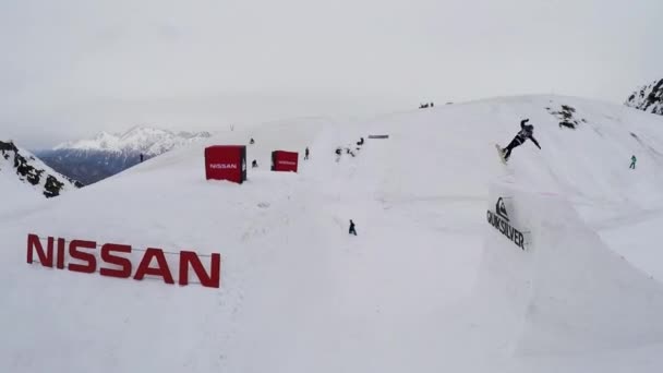 Sochi, Ryssland - April 4, 2016: Quadrocopter skjuta snowboardåkare hoppa från springboard, volter i luften. Landskap. — Stockvideo