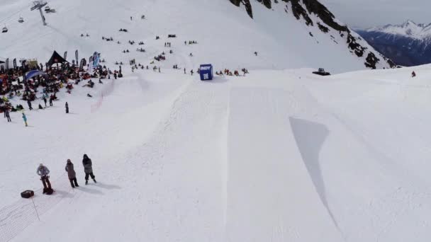 Sochi, Rusko - duben 4, 2016: Quadrocopter natáčení snowboardista jízda na můstek. Lidé. Encamp. Hory — Stock video