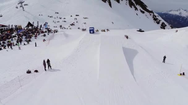 Sochi, Rusko - duben 4, 2016: Převrátí Quadrocopter natáčení snowboardista jízda na springboardmake. Lidé v encamp — Stock video