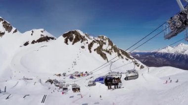 Sochi, Rusya - 4 Nisan 2016: Quadrocopter ateş snowboard ve kayak teleferiği kayakçı. Kayak Merkezi. Dağlar.