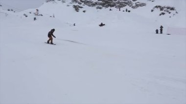 Soçi, Rusya - 4 Nisan 2016: Snowboard binmek yüksek sıçrama tahtası üzerinde havada yapma çevirir. Kayak Merkezi. Dağlar