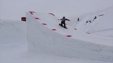 Sochi, Rusya Federasyonu - 4 Nisan 2016: Snowboarder yüksek tramplen atlama, aşırı flip havada olun. Karlı dağ