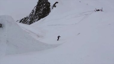 Soçi, Rusya - 4 Nisan 2016: Snowboarder atlama kayak merkezi sıçrama tahtası. Karlı dağlar. Yapmak ters çevir