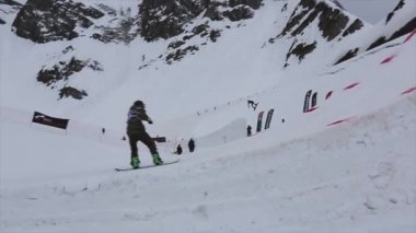 Soçi, Rusya - 4 Nisan 2016: Snowboarder atlama kayak merkezi yüksek sıçrama tahtası. Dağlar. Hile yapmak