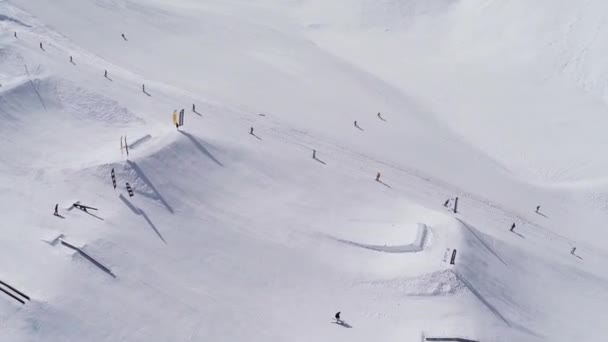 СОЧИ, РОССИЯ - 4 апреля 2016 года: Quadrocopter стрелять сноубордистов и лыжников ездить uo на склоне. Лыжный курорт. Солнечный . — стоковое видео