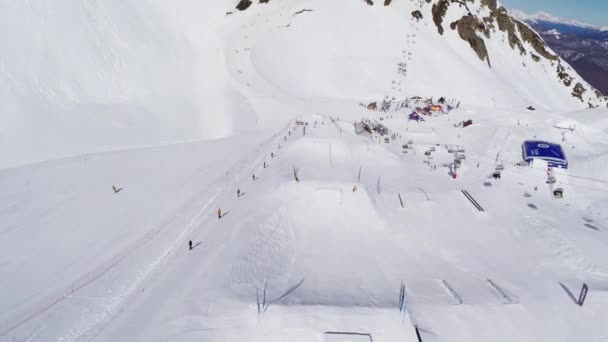 Sochi, Ryssland - April 4, 2016: Quadrocopter flyga över språngbrädor på skidorten. Landskap. Ryttare. Soligt — Stockvideo