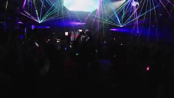 SOCHI, RUSIA - 4 DE ABRIL DE 2016: La gente levanta las manos y salta a la fiesta en el club nocturno. Dj en el escenario. Espectáculo láser. Animación — Vídeos de Stock