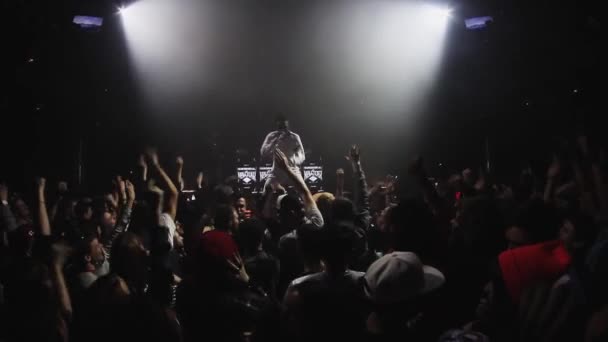 SOCHI, RUSSIA - APRIL 4, 2016: People raise hands jump on party in nightclub. Mc man performing on stage. Dance — Stock Video