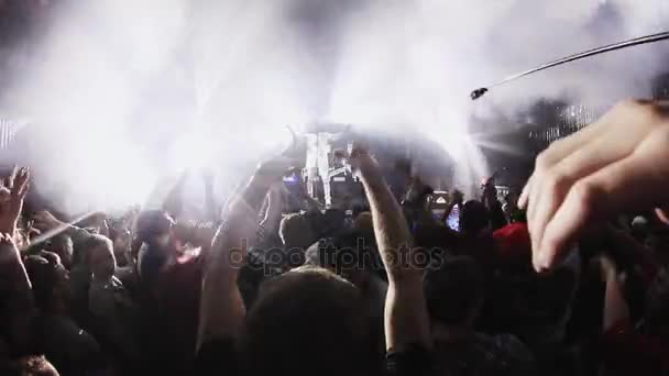 SOCHI, RÚSSIA - 4 de abril de 2016: As pessoas levantam a mão na festa em boate. Mc man atuando no palco. Luzes — Vídeo de Stock