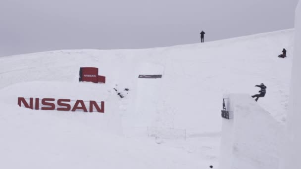 Сочі, Росія - 4 квітня 2016: Сноубордист стрибках з трампліну, зробити захопити. Гірськолижний курорт. Червоний Вивіска. — стокове відео