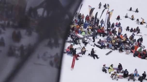 Sotschi, Russland - 4. April 2016: Snowboarder und Skifahrer applaudieren im Lager. Skigebiet. schwarze Fahne schwenkend. — Stockvideo