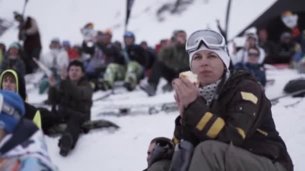 СОЧИ, РОССИЯ - 4 апреля 2016 года: Сноубордисты и лыжники аплодируют в лагере. Лыжный курорт. Наблюдаю за событием. Толпа — стоковое видео