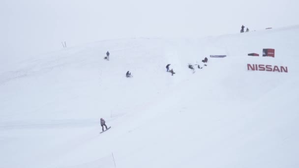 SOCHI, RUSIA - 4 DE ABRIL DE 2016: Paseo en snowboarder en pendiente. Estación de esquí. Paisaje de montañas nevadas. Gente — Vídeos de Stock