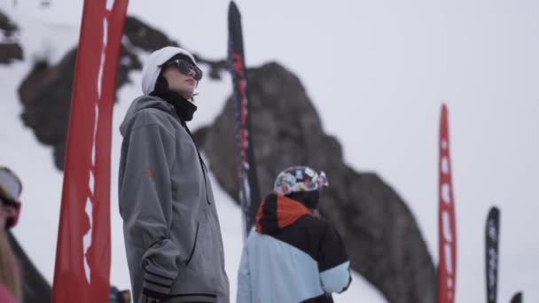 SOCHI, RUSSIA - April 4, 2016: Gadis berkacamata hitam tinggal di kamp bersama orang lain. Resor Ski. Flag melambai . — Stok Video
