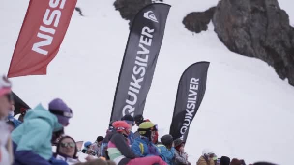 Sochi, Rusko - duben 4, 2016: Encamp snowboardisty a lyžaře relav v. Událost. Lyžařské středisko. Vlající vlajky. — Stock video