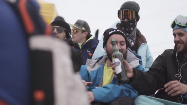 Sochi, Ryssland - April 4, 2016: Snowboardåkare och skidåkare njuta av händelsen i encamp. Lycklig man dricka öl. Ski resort. — Stockvideo