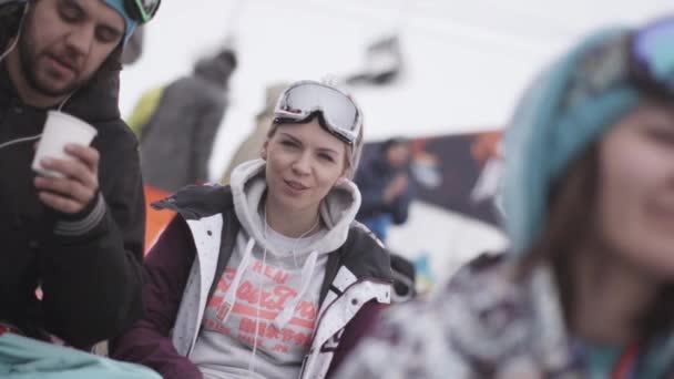 SOCHI, RUSIA - 4 DE ABRIL DE 2016: Los snowboarders y esquiadores disfrutan de un evento en el campamento. Una pareja joven. Estación de esquí . — Vídeos de Stock
