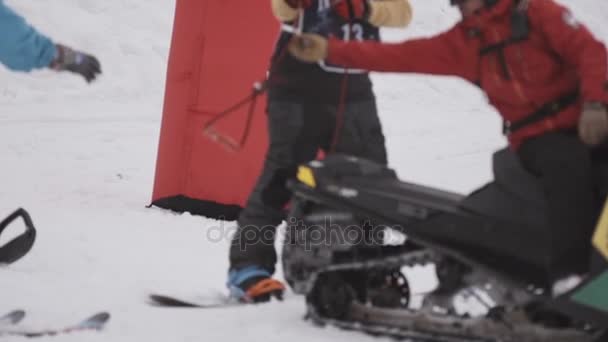 Sochi, Rusland - 4 April 2016: Snowboarder Neem touw van sneeuwscooter op ski-oord. Extreme sport. Hobby. — Stockvideo