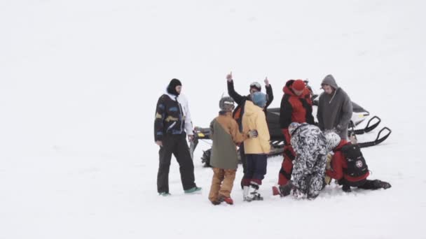 Sochi, Rusland - 4 April 2016: Groep snowboarders sneeuwscooter verblijf. Skigebied. Rider krijgt schade. Sneeuw — Stockvideo